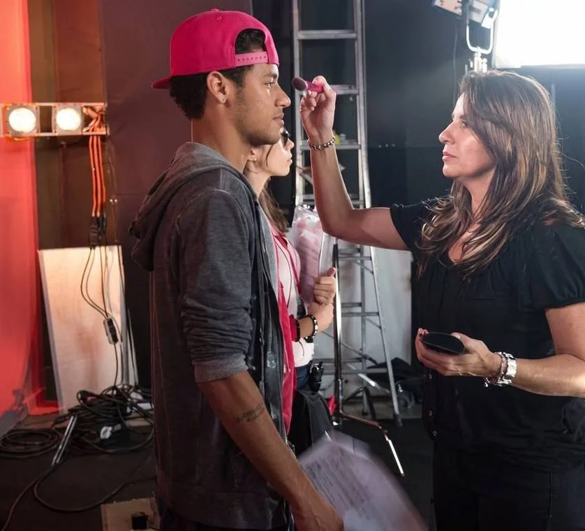 Neymar Jr. em pé, maquiado por Guetti Reis nos bastidores de uma produção